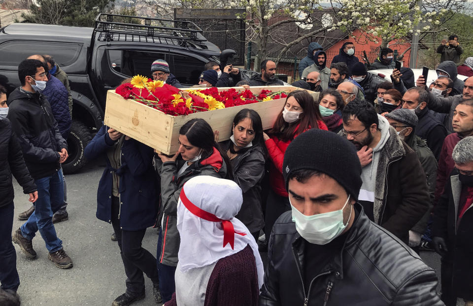 Mourners carry the open coffin of Helin Bolek, a member of a popular folk music group that is banned in Turkey, during the funeral procession in Istanbul, Friday, April 3, 2020. Bolek died at home Friday on the 288th day of a hunger strike protesting the government's treatment of the band, in an effort to force the government to reverse its treatment of the band and its members. She was 28. Grup Yorum, known for its protest songs, is a folk collective with rotating band members, the government accuses the group of links to the outlawed Revolutionary People's Liberation Party-Front, or DHKP/C. (Ibrahim Mase/DHA via AP)