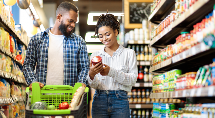 Couple shopping at grocery store together. Consumers. Consumer stocks.