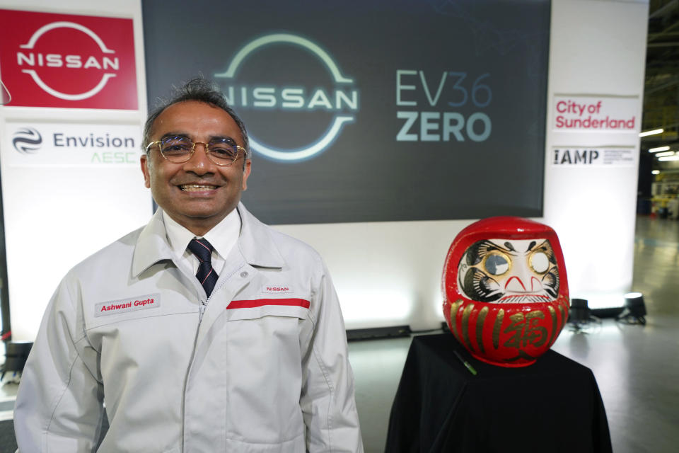 Nissan's Chief Operating Officer Ashwani Gupta poses for a photo next to a Daruma, a hollow, round, Japanese traditional doll regarded as a talisman of good luck,,at the Nissan Motor Co. plant, in Sunderland, England, Thursday July 1, 2021. Japanese carmaker Nissan and two partners announced plans to invest 1 billion ($1.4 billion) pounds to produce a new model of an all-electric vehicle and batteries in northeast England, a major victory for the U.K. government’s efforts to attract jobs and investment following the country’s departure from the European Union. (Owen Humphreys/PA via AP)