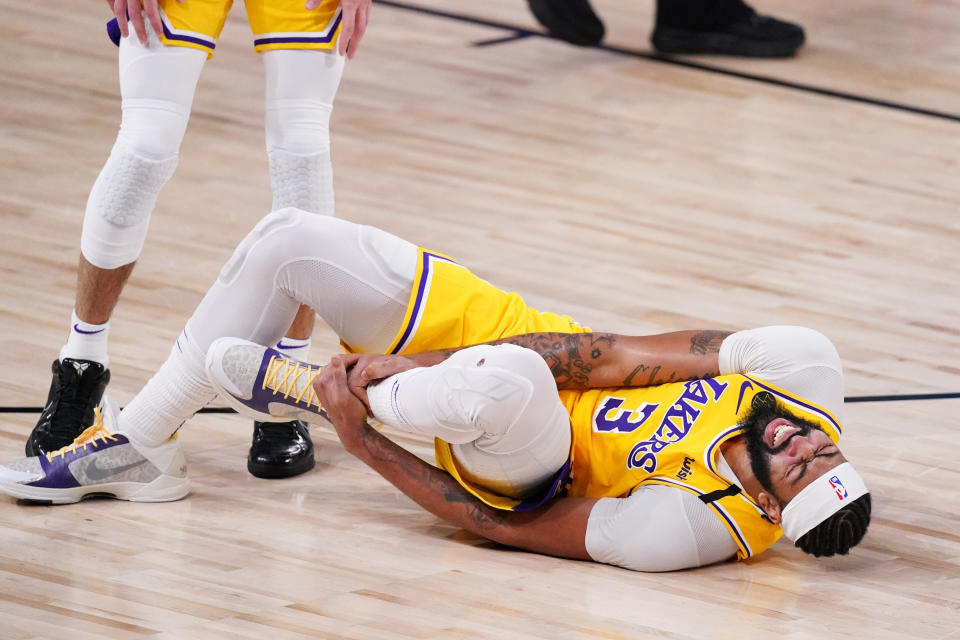 Los Angeles Lakers' Anthony Davis (3) grabs his ankle after a fall during the second half of an NBA conference final playoff basketball game against the Denver Nuggets Thursday, Sept. 24, 2020, in Lake Buena Vista, Fla. (AP Photo/Mark J. Terrill)