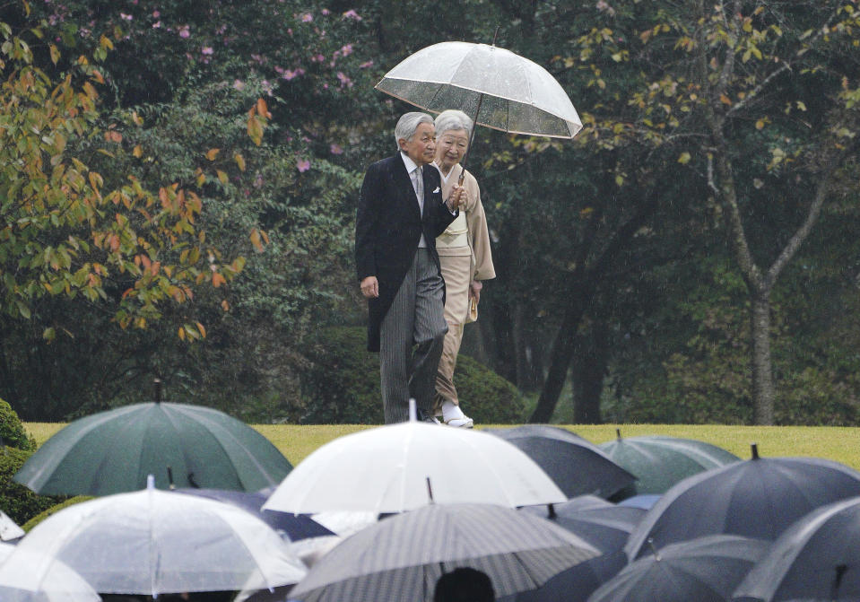 FILE - In this Nov. 9, 2018, file photo, Japan's Emperor Akihito and Empress Michiko walk down a hill to greet guests during the autumn garden party at the Akasaka Palace imperial garden in Tokyo. Japan’s Emperor Akihito has devoted his 30-year reign to making amends for a war fought in his father’s name, while adapting the 1,500-year-old monarchy’s traditions to draw the Imperial Family closer to the public. Akihito’s subtle public comments and insights from his classmates show him to be determined but also open to new ideas. He’s shown a keen awareness of his duties. (AP Photo/Eugene Hoshiko, File)