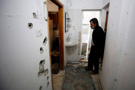 A man inspects the damage in a house where a Palestinian gunman was killed by Israeli forces, near Nablus in the Israeli-occupied West Bank December 13, 2018. REUTERS/Abed Omar Qusini