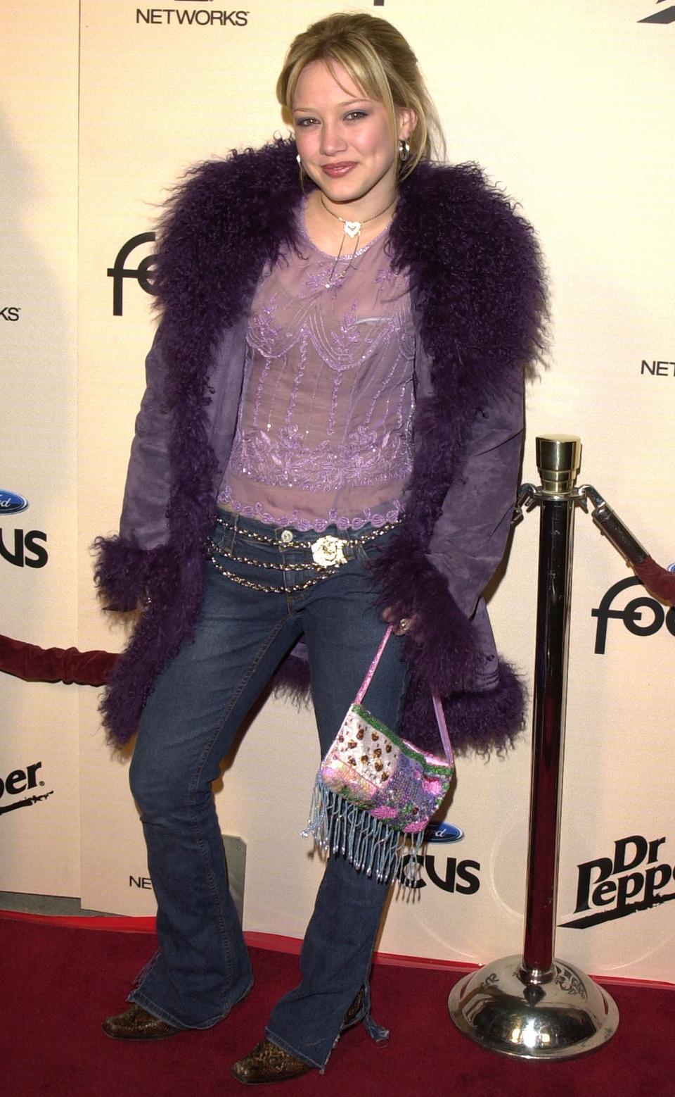 Between the beaded bag, the fur-trimmed purple coat, matching purple lace shirt and chain belts, there is so much happening here. 