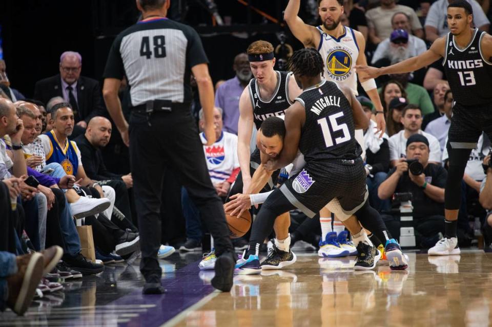 Golden State Warriors guard Stephen Curry (30) is swarmed by Sacramento Kings Kevin Huerter (9) and Davion Mitchell (15) during Game 7 of the first-round NBA playoff series at Golden 1 Center on Sunday, April 30, 2023.