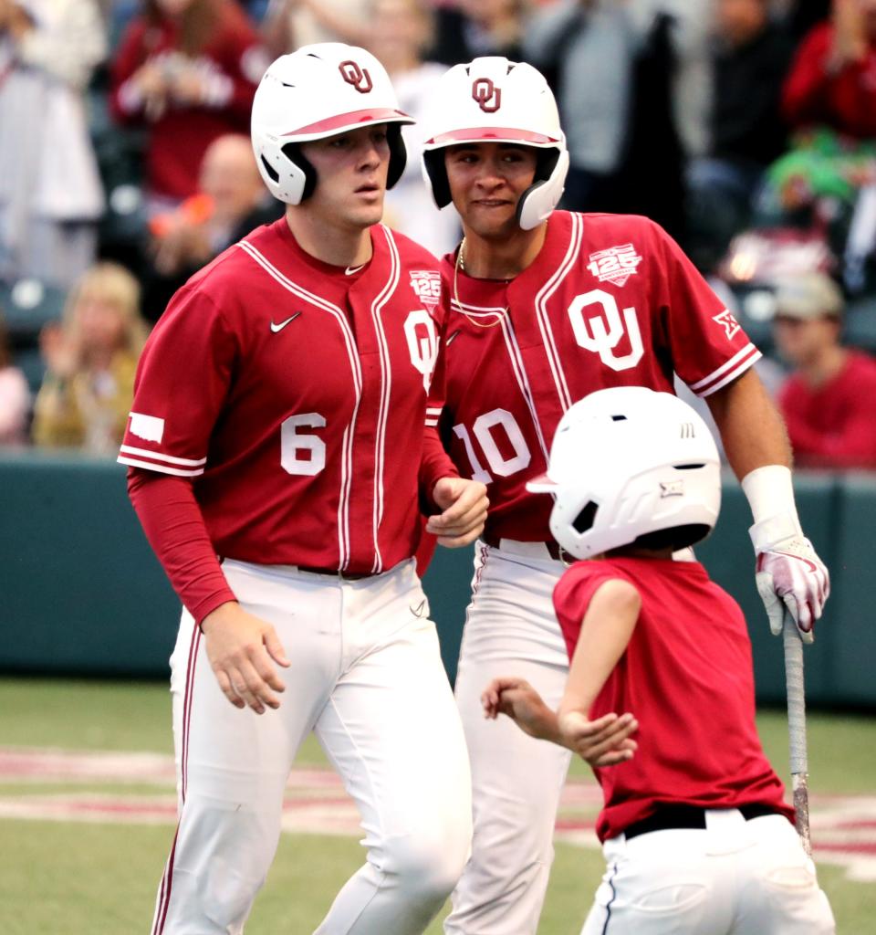 Wallace Clark is greeted at home after being brought in by Anthony Mackenzie's triple as the University of Oklahoma Sooners (OU) play the Oklahoma State Cowboys (OSU) in Bedlam baseball on May 19, 2023 at L Dale Mitchell Park in Norman, Okla.  [Steve Sisney/For The Oklahoman]