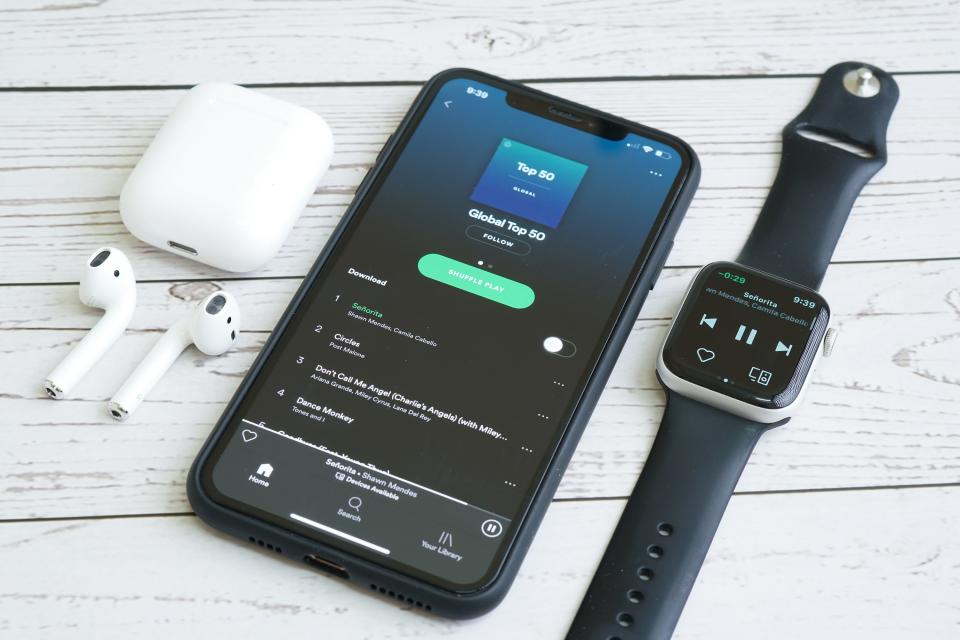 Composition of iPhone, Apple Watch and Airpods while using Spotify online music streaming apps.  M