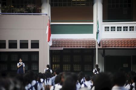 The state flag is pictured at half-mast as the National Pledge is recited during morning assembly at Raffles Girls Secondary School in Singapore March 23, 2015. REUTERS/Timothy Sim