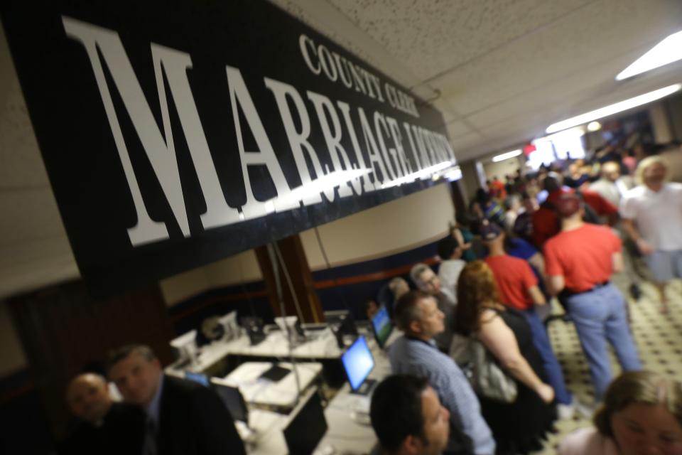 Gay couples line up to file paperwork for marriage licenses at the Pulaski County Courthouse in Little Rock, Ark., Monday, May12, 2014. The state's largest county began issuing gay marriage licenses following a judge's ruling overturning Arkansas' constitutional ban on same-sex marriage. (AP Photo/Danny Johnston)