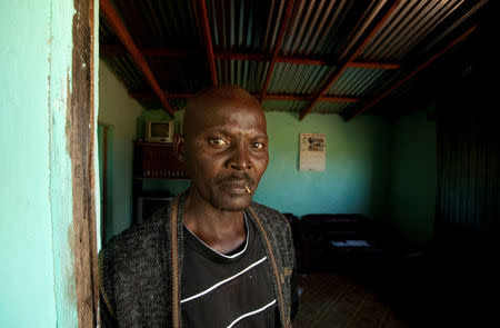 Former gold miner Thulani Bitsha, 39, who contracted silicosis while working underground, stands in the doorway to his home near Bizana in South Africa's impoverished Eastern Cape province, March 7, 2012. REUTERS/Mike Hutchings/File Photo