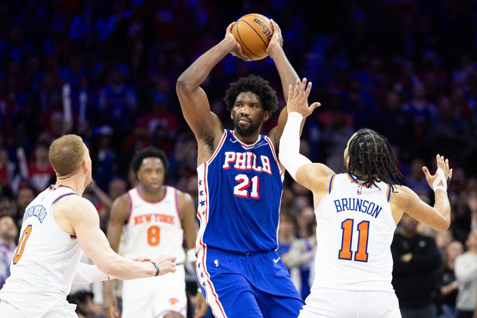 Philadelphia 76ers center Joel Embiid (21) controls the ball in front of New York Knicks guard Jalen Brunson (11) and guard Donte DiVincenzo (0) during the second half of Game 3 of the first round of the 2024 NBA playoffs at Wells Fargo Center.