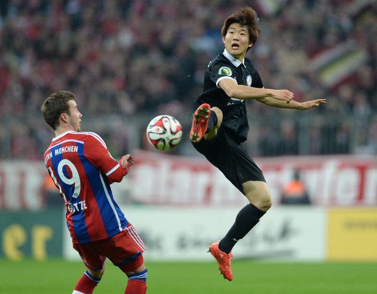 Braunschweig's Korean midfielder Seung-Woo Ryu (R) and Bayern Munich's midfielder Mario Goetze vie for the ball during their German football Cup DFB Pokal round of 16 match in Munich, Germany, on March 4, 2015