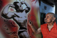 Indian body builder Manohar Aich, on the eve of his 100th birthday, looks at a print of one of his pictures hanging in a gymnasium, in Kolkata on March 16, 2012.