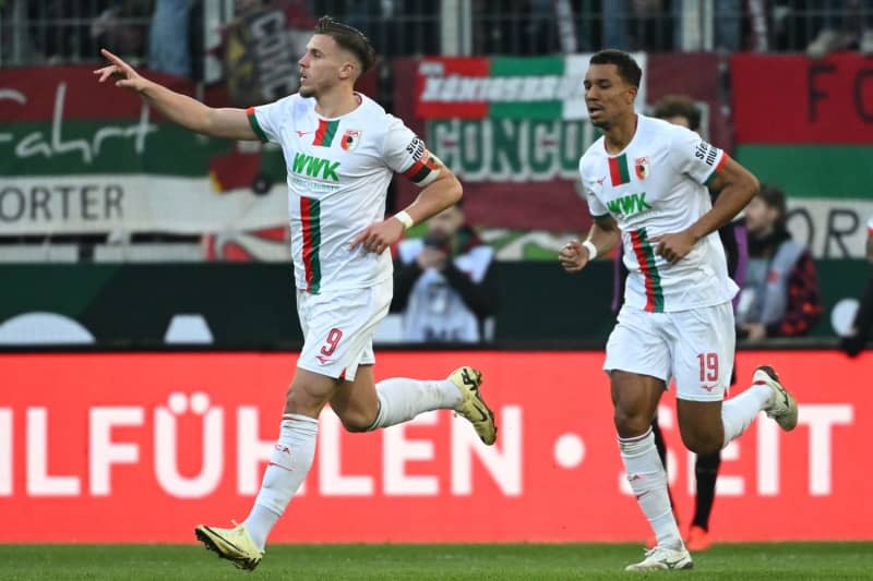 Augsburg's Ermedin Demirovic (L) celebrates with Felix Uduokhai after scoring his side's first goal of the game during the German Bundesliga soccer match between FC Augsburg and Bayern Munich at the WWK-Arena. Sven Hoppe/dpa
