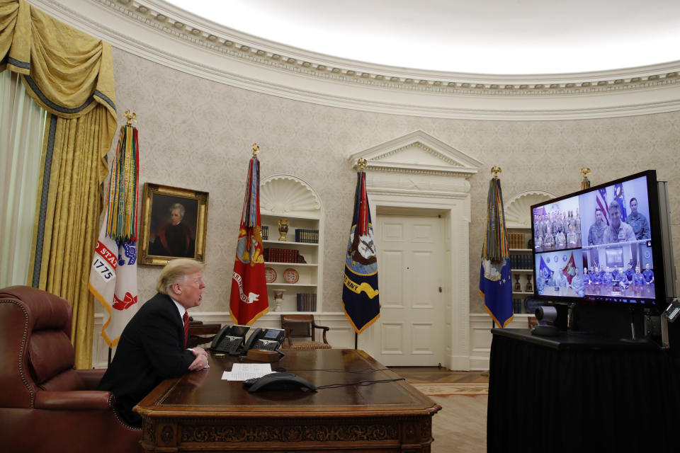 President Donald Trump greets members of the five branches of the military via video conference on Christmas Day, Tuesday, Dec. 25, 2018, in the Oval Office of the White House. The military members were stationed in Guam, Qatar, Alaska, and two in Bahrain. (AP Photo/Jacquelyn Martin)