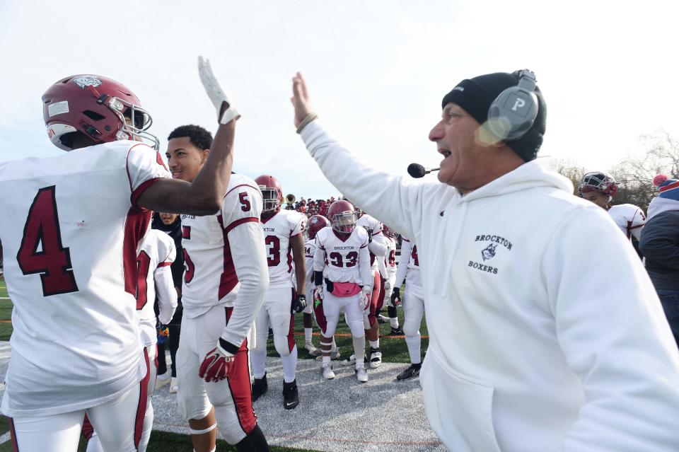 Brockton head football coach Peter Colombo high-fives Cameron Monteiro after his touchdown catch during the Thanksgiving Day game against Bridgewater-Raynham on Thursday, Nov. 25, 2021.