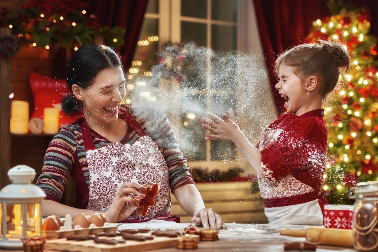 mother and daughter having fun cooking cookies during the holidays