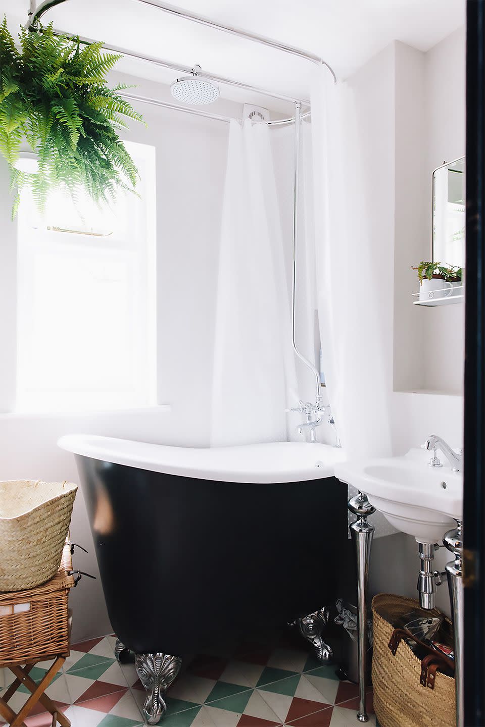 a bathroom with a black freestanding tub and sink