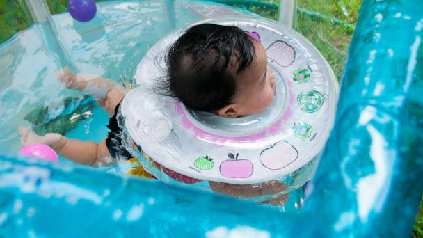 PHOTO: A baby girl swims while wearing an infant neck float in Bangkok, July 29, 2017. (STOCK PHOTO/Mrvirgin/Shutterstock)