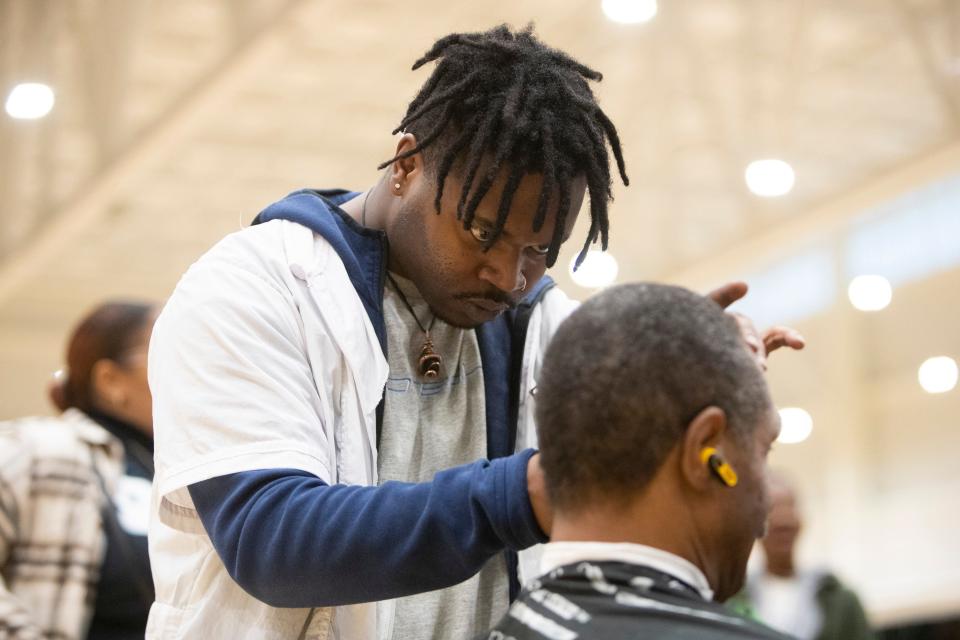 Donavon Ward, a barbering student at Tennessee College of Applied Technology, gives an unhoused man a hair cut during the Project Homeless Connect event at the Memphis Sports and Events Center in Memphis, Tenn., on Thursday, January 25, 2024.