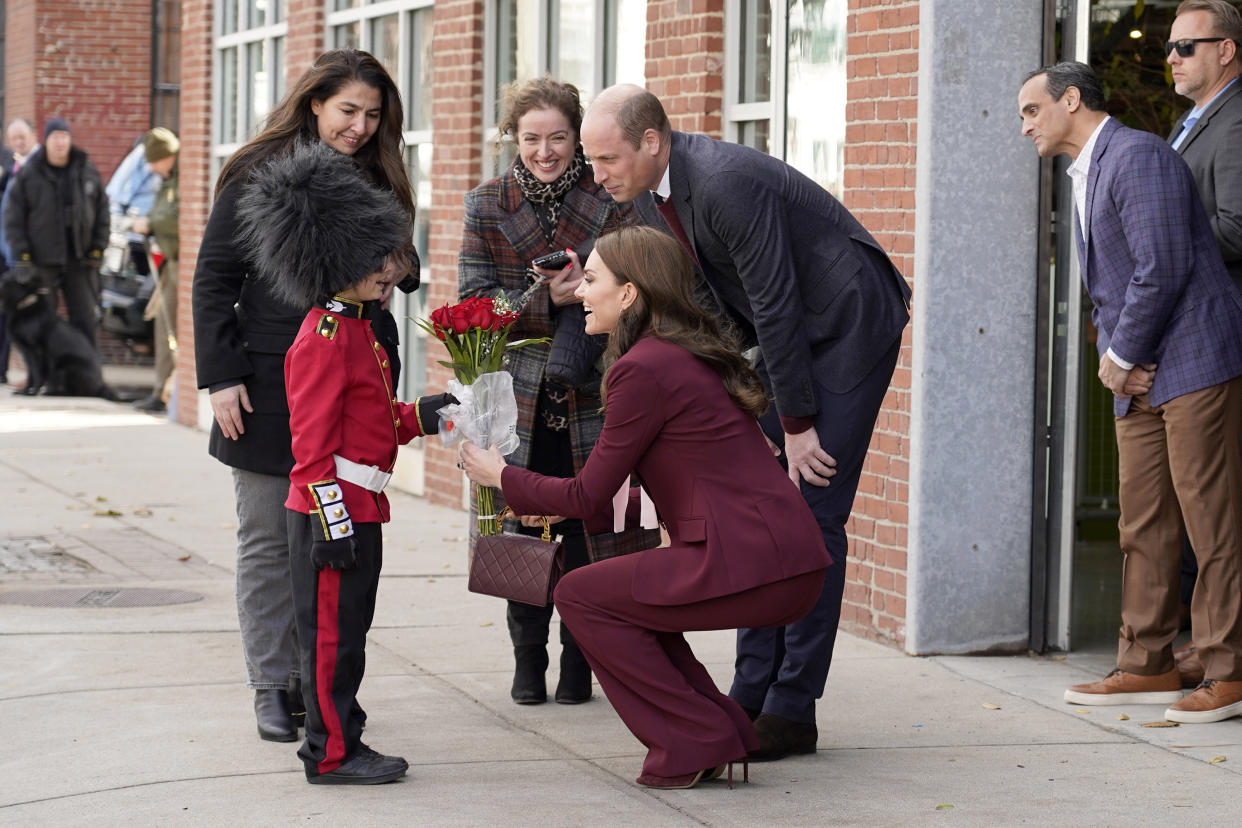 Henry Dynov-Teixeira, 8, of Somerville, presents flowers to Britain's Prince William and Kate, Princess of Wales, as his parents Melissa, left, and Irene, look on following a visit to Greentown Labs, Thursday, Dec. 1, 2022, in Somerville, Mass. (AP Photo/Mary Schwalm)