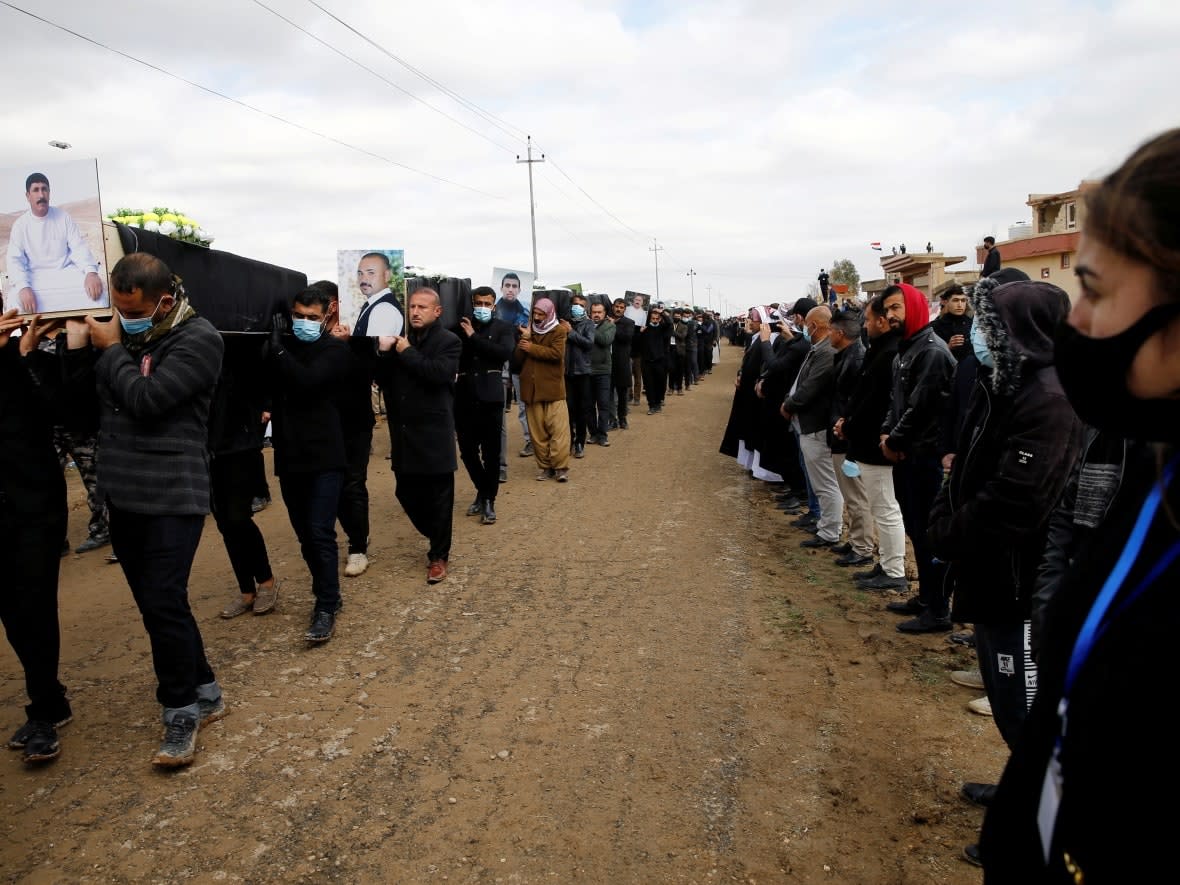 Mourners carry the remains of Yazidi victims of ISIS following their exhumation from a mass grave near Kojo, Iraq on February 6, 2021. (Reuters - image credit)