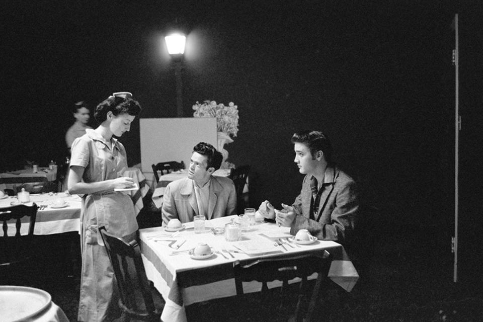 ‘May I take your order?’: Elvis prepares to turn on the charm with a waitress at the Hotel Jefferson in Richmond, Virginia (Alfred Wertheimer/ Taschen)