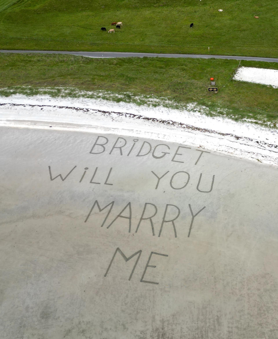 "Bridget will you marry me" ("Bridget, willst du mich heiraten") steht im Sand der Landebahn, den Heiratsantrag konnte Bridget Byrne beim Landeanflug auf die schottische Insel aus dem Flugzeugfenster lesen (Bild: Stephen McCann/Big Partnership /dpa)