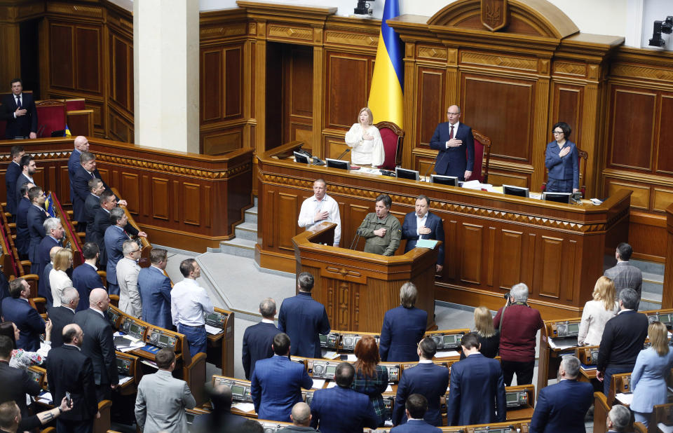Ukrainian lawmakers sing the national anthem after a vote, in parliament, in Kiev, Ukraine,Thursday, April 25, 2019. The Ukrainian parliament has approved a controversial language law in the largely bilingual country which provides for the mandatory use of the national language by government agencies, local self-government and in other spheres of public life. (AP Photo/Efrem Lukatsky)