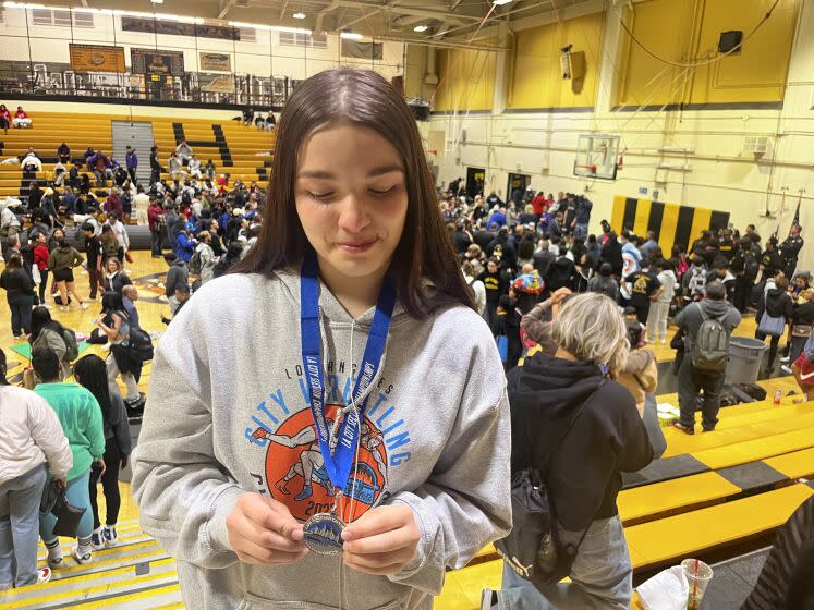 A teary eyed Melissa Guerrero-Brown, a junior at Banning, inspects a silver medal.