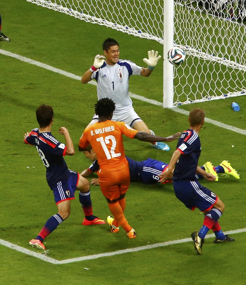 Ivory Coast's Wilfried Bony tries unsuccessfully to score past Japan's goalkeeper Eiji Kawashima and Japan's Masato Morishige (6) during their 2014 World Cup Group C soccer match at the Pernambuco arena in Recife June 14, 2014. REUTERS/Ruben Sprich