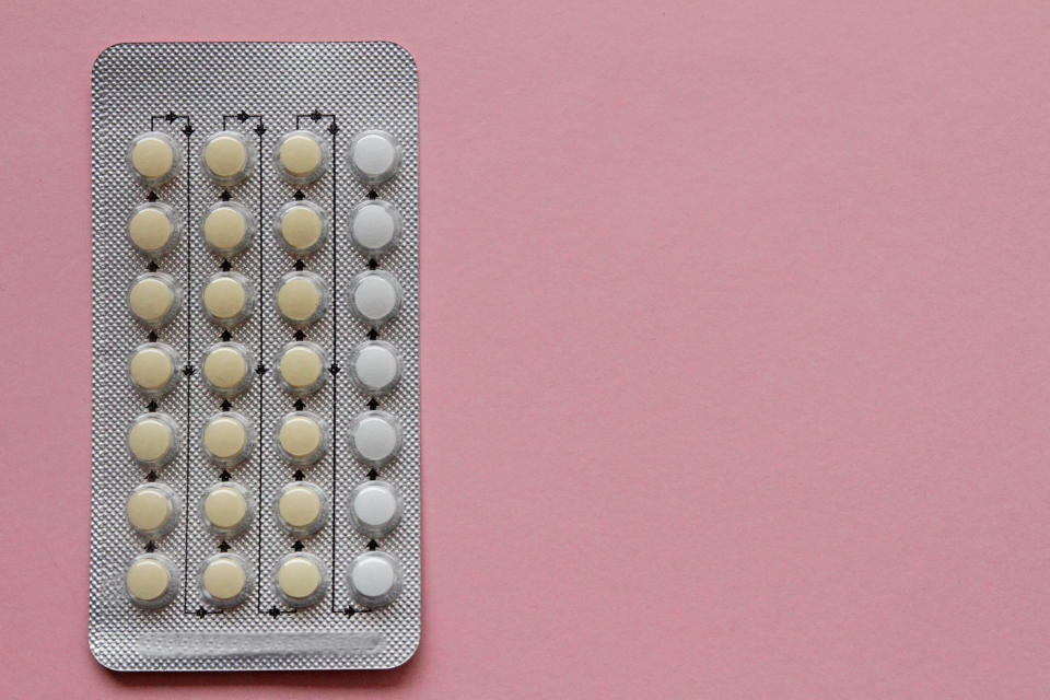 Blister pack of pills with varying shades, some rows partially used, on a plain background