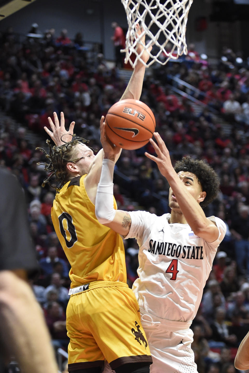 San Diego State guard Trey Pulliam (4) shoots past Wyoming guard Jake Hendricks (0) during the first half of an NCAA college basketball game Tuesday, Jan. 21, 2020, in San Diego. (AP Photo/Denis Poroy)