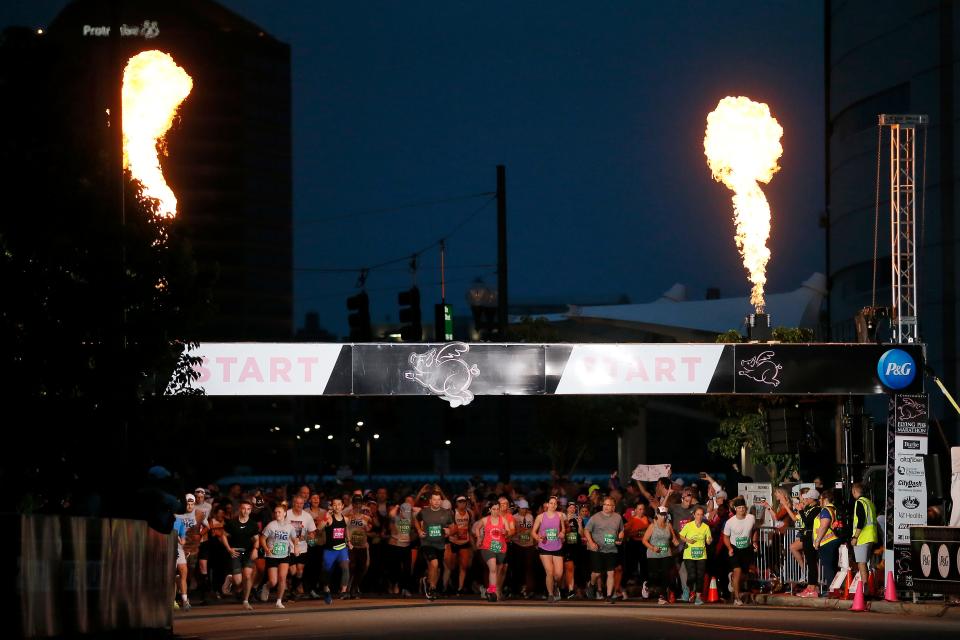 Flames erupt at the start of a running group at the starting line of the 2022 Flying Pig Marathon.