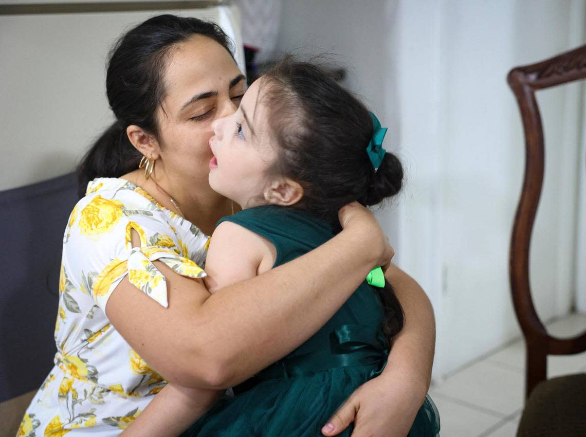 Beatriz Perez, left, kisses her daughter Katherin Leyva, 5, in their apartment on Thursday, Dec. 1, 2022, in Hialeah. Leyva is diagnosed with Austism Spectrum Disorder. The family lost the majority of their possessions in a fire.