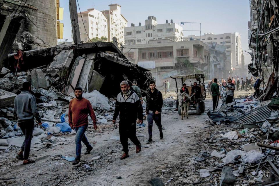 Palestinians walk amid the rubble of destroyed buildings in Gaza City on Friday (AFP via Getty Images)