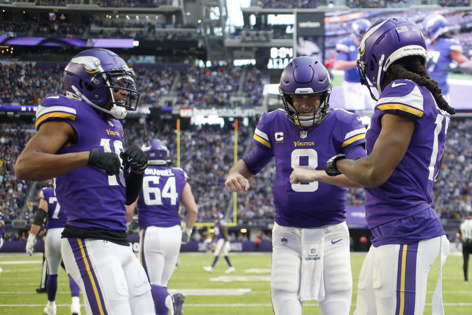 Minnesota Vikings wide receiver K.J. Osborn, right, celebrates with teammates wide receiver Justin Jefferson, left, and quarterback Kirk Cousins (8) after catching a 21-yard touchdown pass during the second half of an NFL football game against the Chicago Bears, Sunday, Jan. 9, 2022, in Minneapolis. (AP Photo/Bruce Kluckhohn)