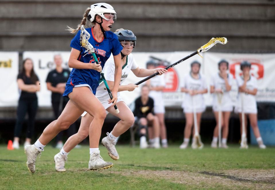 Bolles' Anna Giordano (No. 21) attacks the Catholic end of the field as the Crusader's Ella Adams (No. 15) defends during Friday's District 1-A girls' lacrosse semi-finals match. 