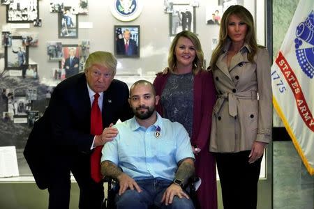 U.S. President Donald Trump poses for a photo with Army Sgt First Class Alvaro Barrientos, his wife Tammy and First Lady Melania Trump (R) after awarding him a Purple Heart at Walter Reed National Military Medical Center in Bethesda, Maryland, U.S., April 22, 2017. REUTERS/Yuri Gripas