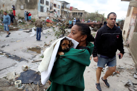 A woman holds her dog after a tornado ripped through a neighbourhood, in Havana, Cuba January 28, 2019. REUTERS/Fernando Medina