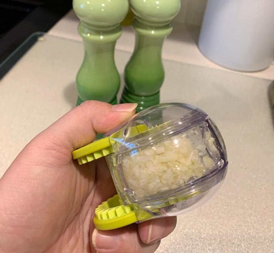 reviewer holding chopper filled with chopped garlic