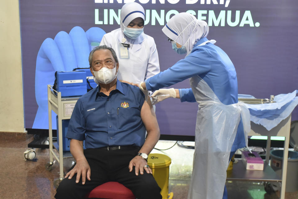 Malaysia's Prime Minister Muhyiddin Yassin receives the first dose of the Pfizer-BioNTech COVID-19 vaccine at a clinic in Putrajaya, Malaysia, Wednesday, Feb. 24, 2021. (Malaysia Health Ministry via AP)