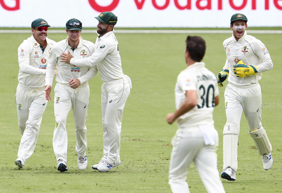 Australia's Steve Smith, second left, is congratulated by teammates after taking a catch to dismiss India's Shubman Gill during play on day two of the fourth cricket test between India and Australia at the Gabba, Brisbane, Australia, Saturday, Jan. 16, 2021. (AP Photo/Tertius Pickard)