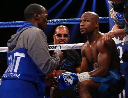 Trainer/father Floyd Mayweather Sr. gives instructions to his son, Floyd Mayweather Jr., between rounds against Canelo Alvarez in 2013. (Photo by Al Bello/Getty Images)