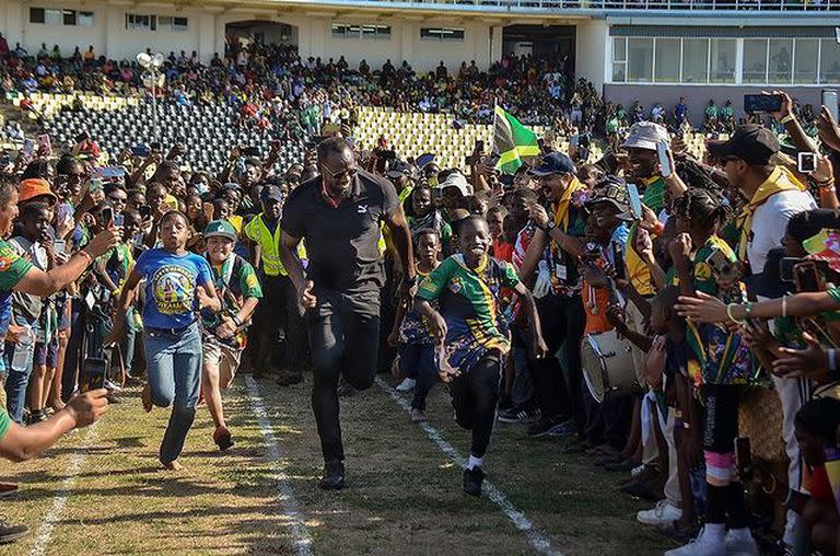 Usain Bolt corriendo con niños, en Jamaica