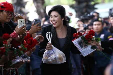 Ousted former Thai prime minister Yingluck Shinawatra greets supporters as she arrives at the Supreme Court in Bangkok, Thailand, August 1, 2017. REUTERS/Athit Perawongmetha