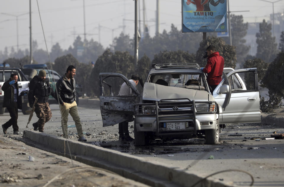 FILE - in this Feb. 2, 2021 file photo, security personnel inspect the site of a bomb attack in Kabul, Afghanistan. After 20 years of military engagement and billions of dollars spent, NATO and the United States still grapple with the same seemingly intractable conundrum — how to withdraw troops from Afghanistan without abandoning the country to even more mayhem. Despite nearly $1 trillion spent in Afghanistan — of which a lion's share went on security — lawlessness is rampant. (AP Photo/Rahmat Gul, File)