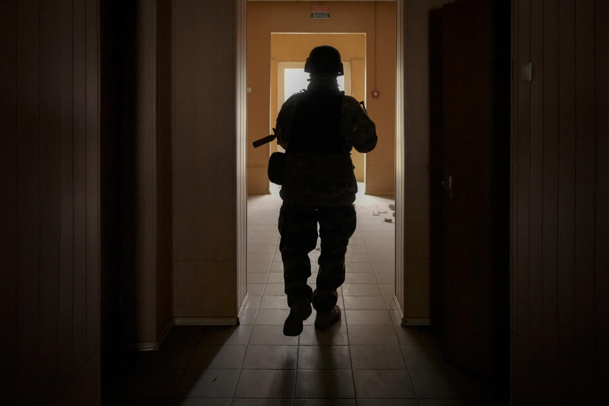 A Ukrainian serviceman walks in a heavily damaged building in Stoyanka, Ukraine, Sunday, March 27, 2022. Ukrainian President Volodymyr Zelenskyy accused the West of lacking courage as his country fights to stave off Russia's invading troops, making an exasperated plea for fighter jets and tanks to sustain a defense in a conflict that has ground into a war of attrition. (AP Photo/Vadim Ghirda)