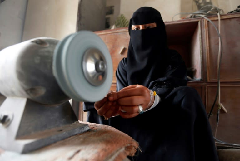 Safaa al-Faqih, one of the few female Yemeni craftsmen working in the precious stones industry in Yemen, crafts a stone in the old city of the capital, Sanaa