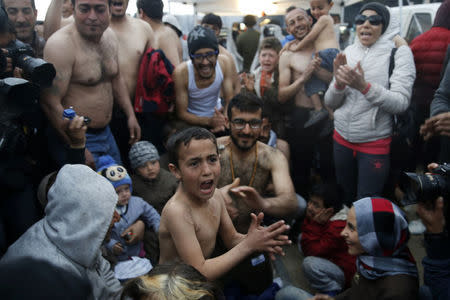 Migrants who are waiting to cross the Greek-Macedonian border, shout slogans during a protest at a makeshift camp near the village of Idomeni, Greece March 7, 2016. REUTERS/Marko Djurica