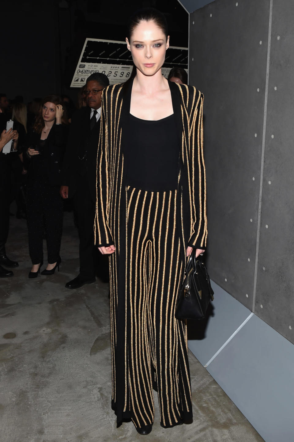 Coco Rocha in gold striped sweater and pants at the Balmain x H&M party. 